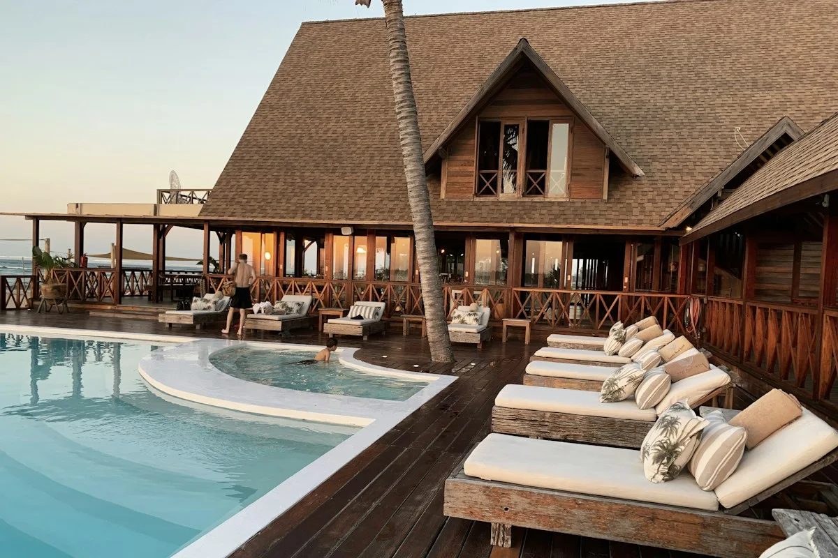 Poolside loungers outside a thatched-roof hotel